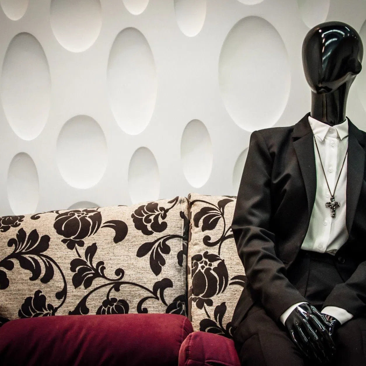 3D Gypsum Wall Panels – ELLIPSE - Gypsum panels with oval cutouts in a modern interior, featuring a decorative mannequin and patterned sofa | DecorMania UK