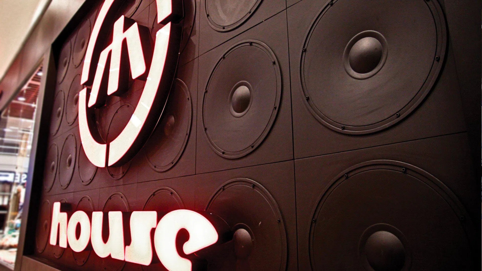 3D Wall Panel - SPEAKER – Close-up of gypsum panels with a speaker-inspired design used as a storefront backdrop with illuminated signage | DecorMania UK