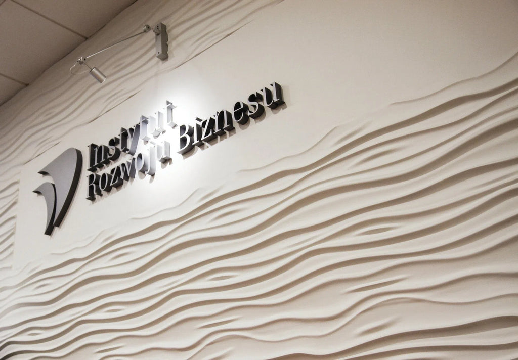 3D Wall Panel - STREAM - Gypsum panels with a flowing wave texture used as a backdrop for a business institute sign | DecorMania UK