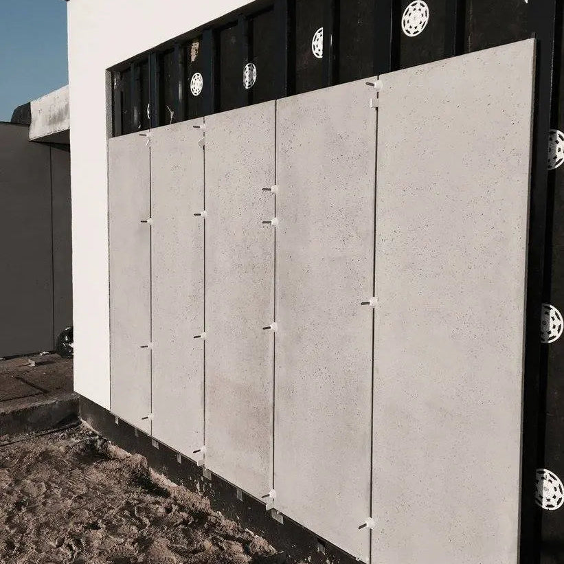 Building exterior with concrete panels and black window frames.