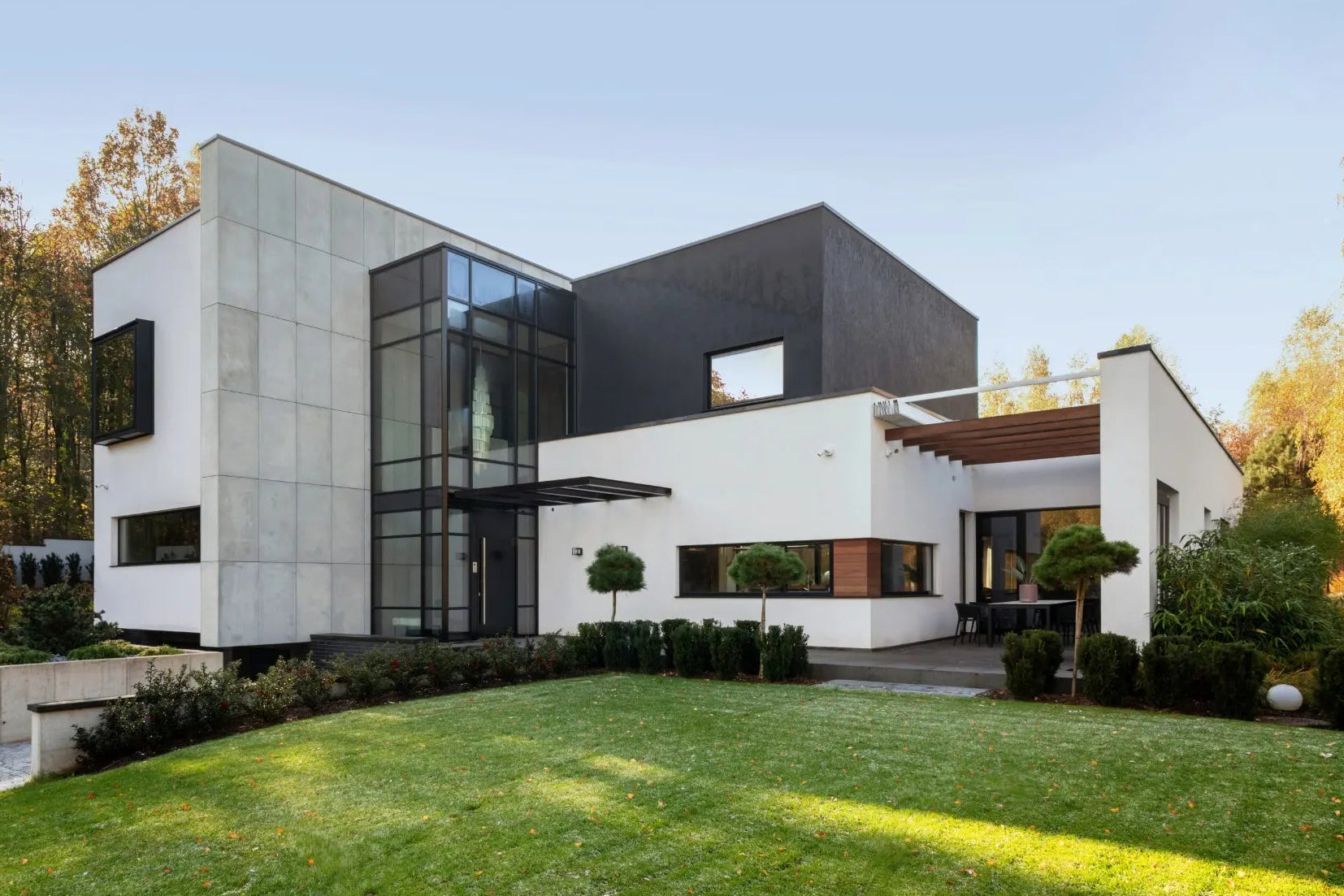 Modern house with a well-maintained lawn and trees in the background