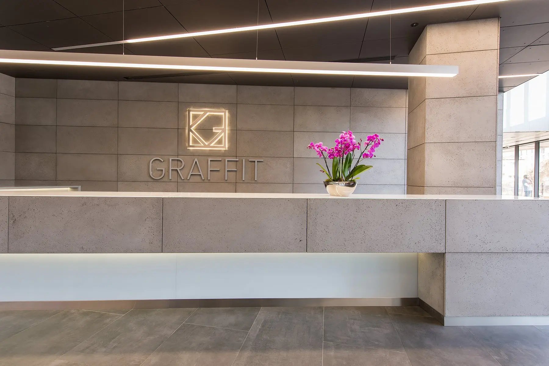 Modern office concrete panelling reception area with 'Graffit' logo on the concrete wall.