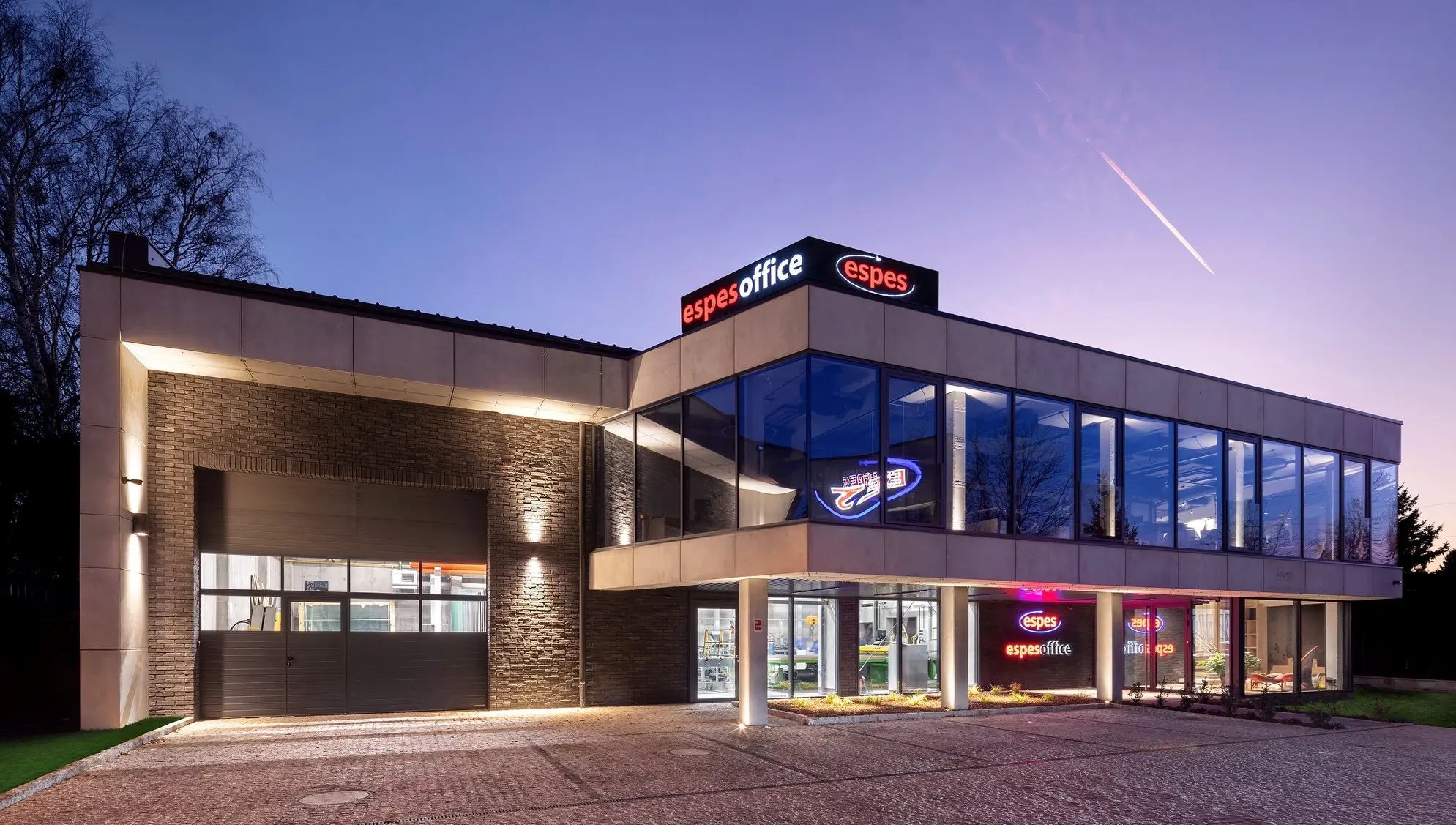 Modern office with exterior concrete wall panels, building with 'superoffice' branding at dusk.