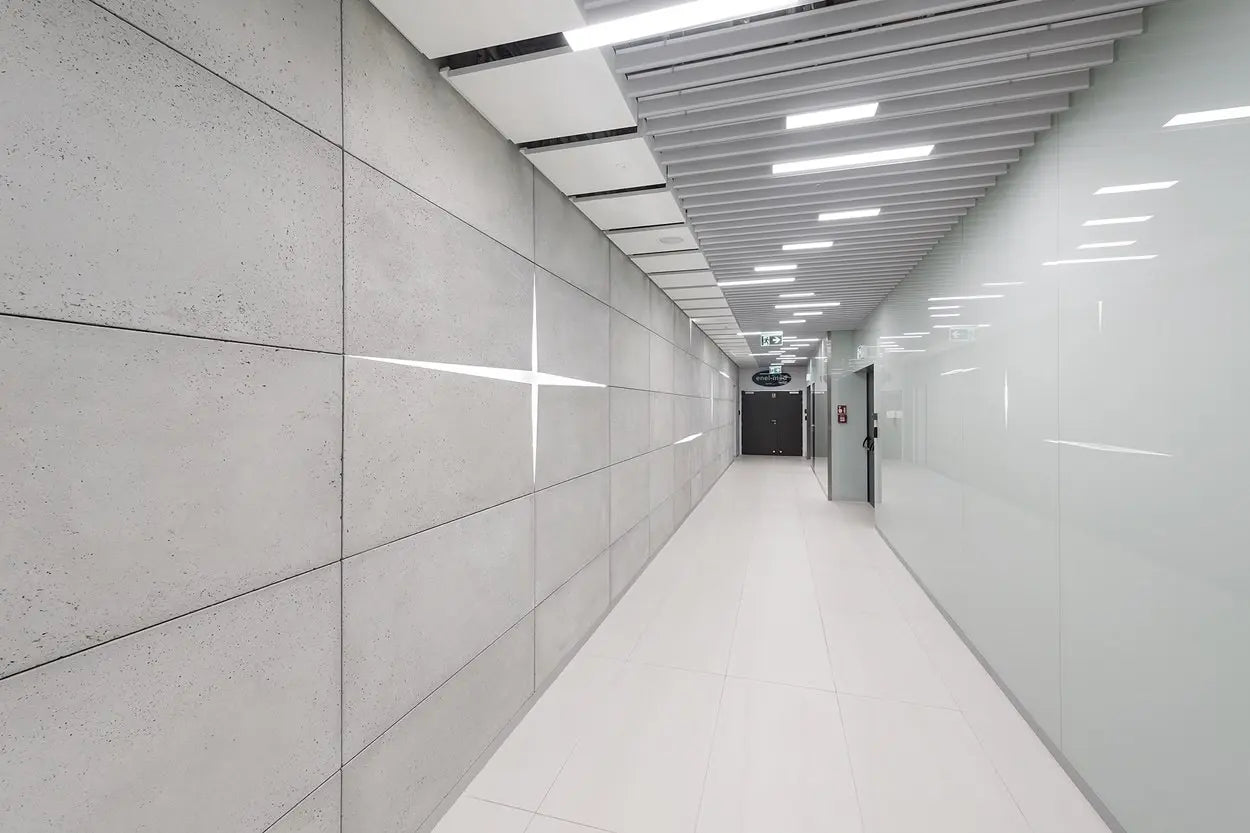 Long, narrow hallway with white walls and ceiling lights.