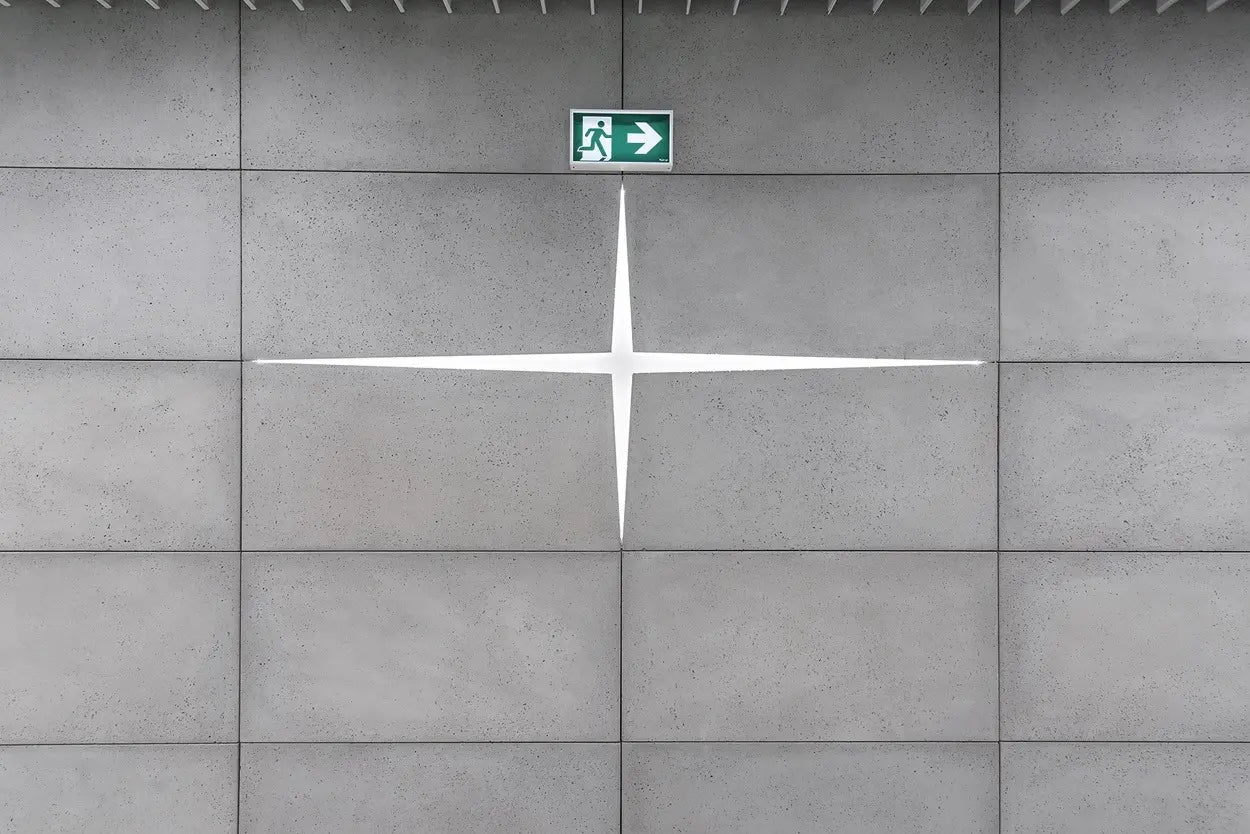 Emergency exit sign on a tiled concrete panels wall