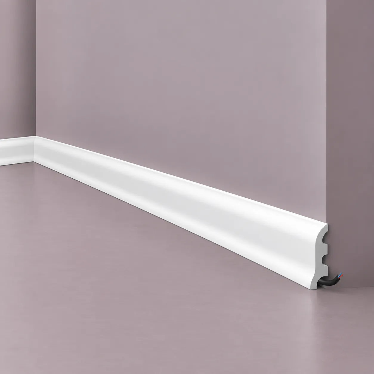 Close-up of a white FL3 skirting board with a rounded decorative profile and concealed cable channel, installed along a muted grey-mauve wall
