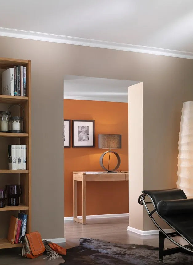 White FL3 skirting board installed around a doorway in a contemporary living room with warm taupe and terracotta walls, wooden furniture and modern décor