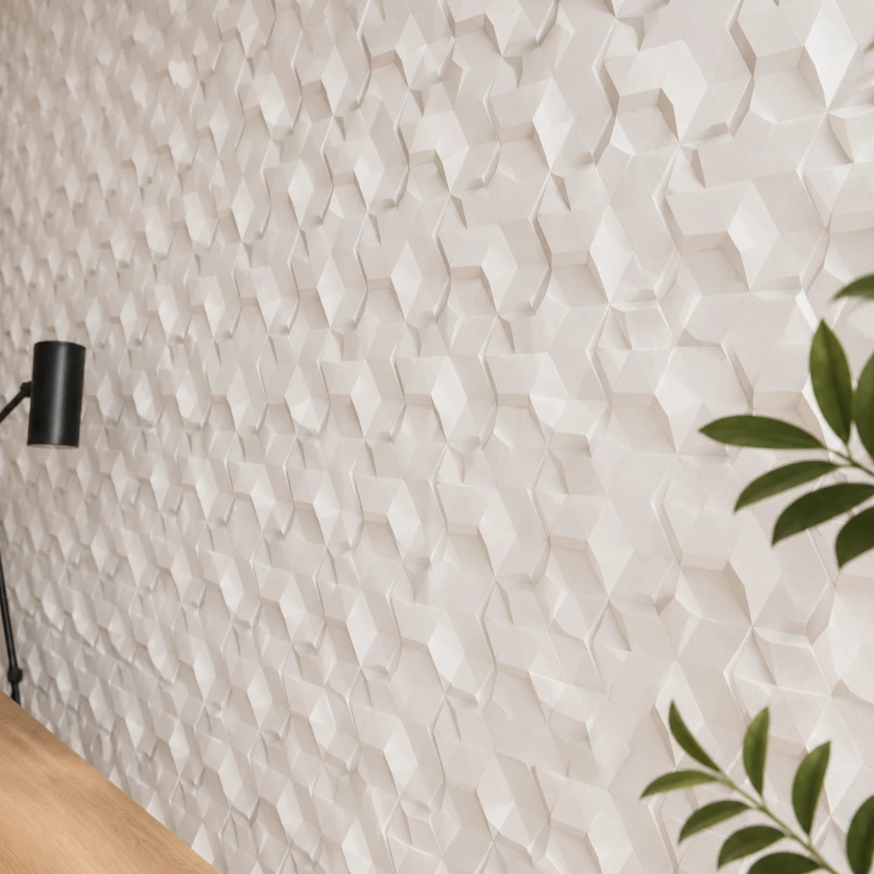 Close-up of white HEXA-2 3D polystyrene wall panels showing their geometric relief and textured surface