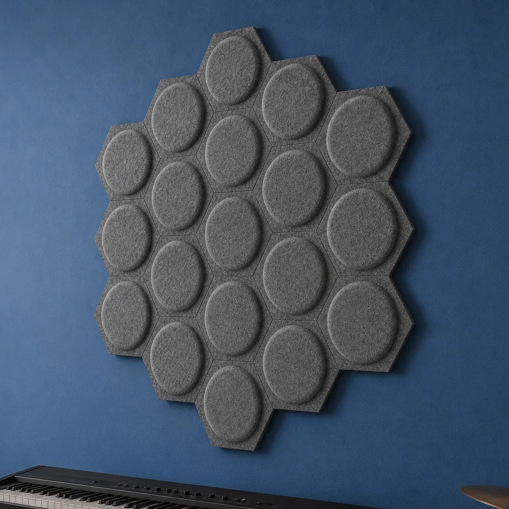 Close-up of grey hexagonal felt acoustic panels with raised circular centres mounted on a blue wall
