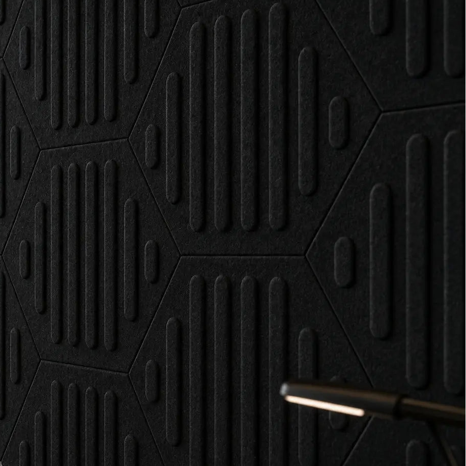 Close-up of black HEXA RIFT 3D felt wall panels showing the geometric layout, raised relief and fibrous texture