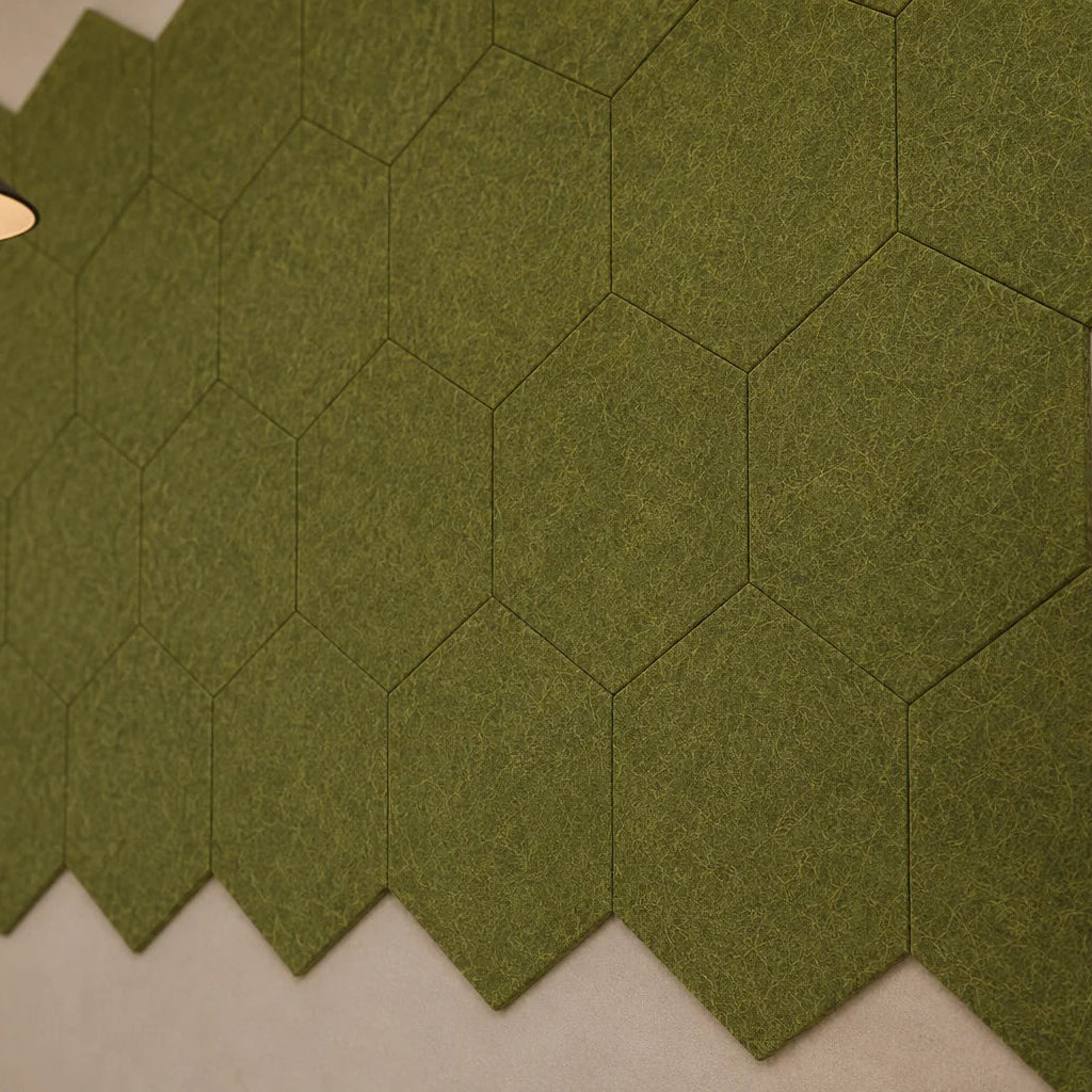 Close-up of olive hexagonal acoustic panels showing their flat profile, precise joints and fibrous felt texture