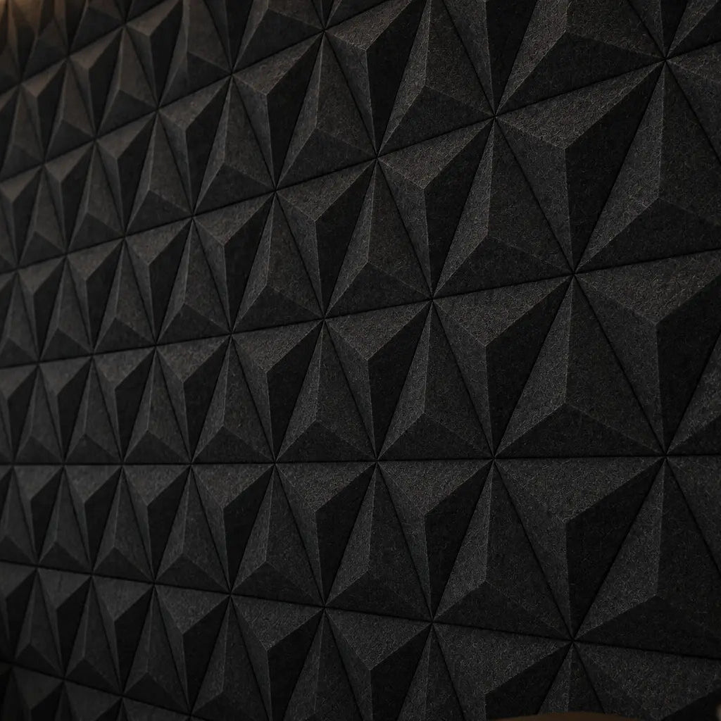 Close-up of black PYRAMID 3D acoustic felt wall panels, showing the geometric pattern, subtle relief and textured PET felt surface