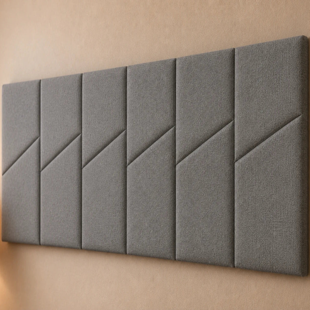 Close-up angled view of six grey padded wall panels, showing the woven fabric texture, diagonal seams and panel depth.