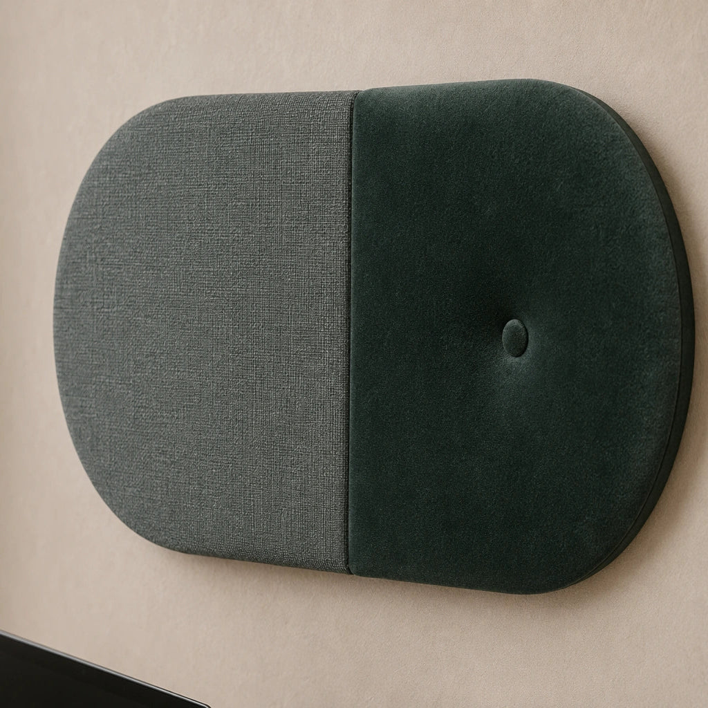 Close-up angled view of a two-tone green upholstered wall panel, highlighting its rounded shape, central seam, button detail and contrasting woven and velvety textures
