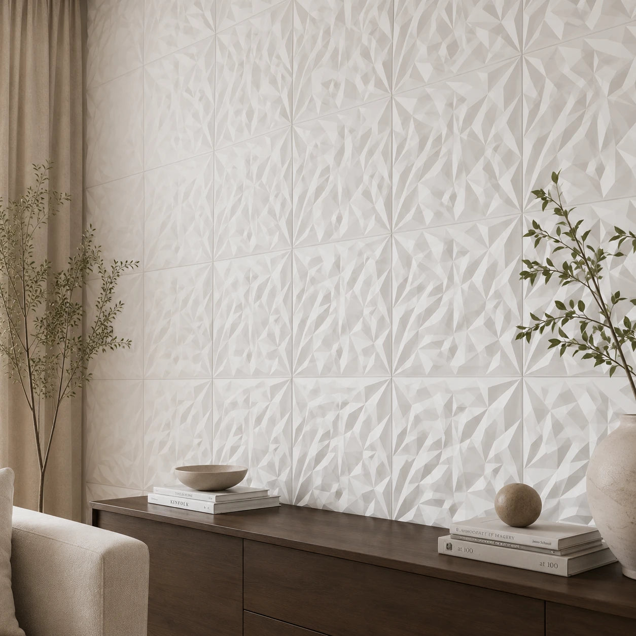 Close-up angled view of white square 3D wall panels with sharp faceted relief, showing the regular grid, panel joints, and part of the dark wood sideboard and decorative objects.