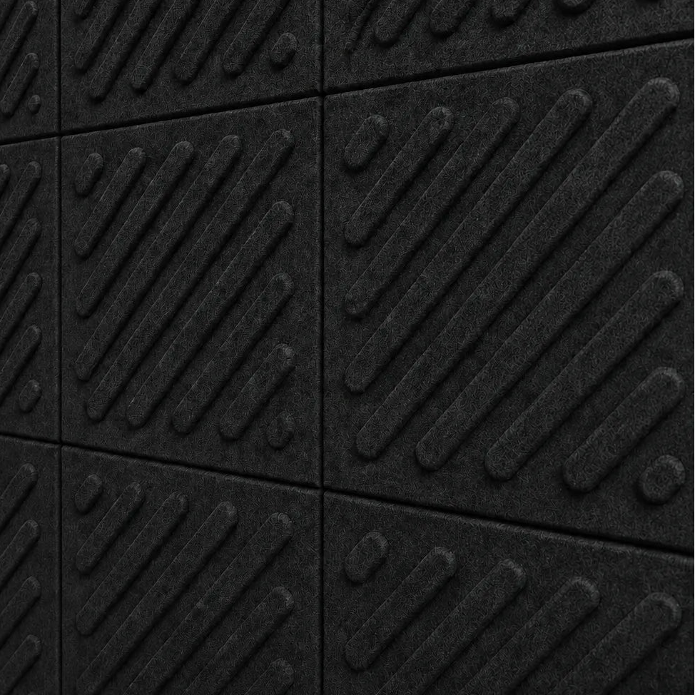 Close-up of black acoustic felt wall panels highlighting the fibrous texture, raised relief and module connections