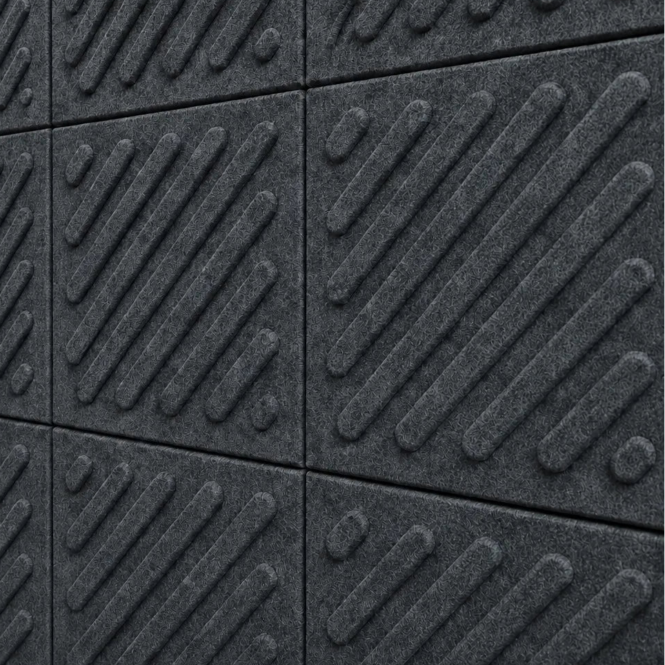 Close-up of grey acoustic felt wall panels highlighting the fibrous texture, raised relief and module connections