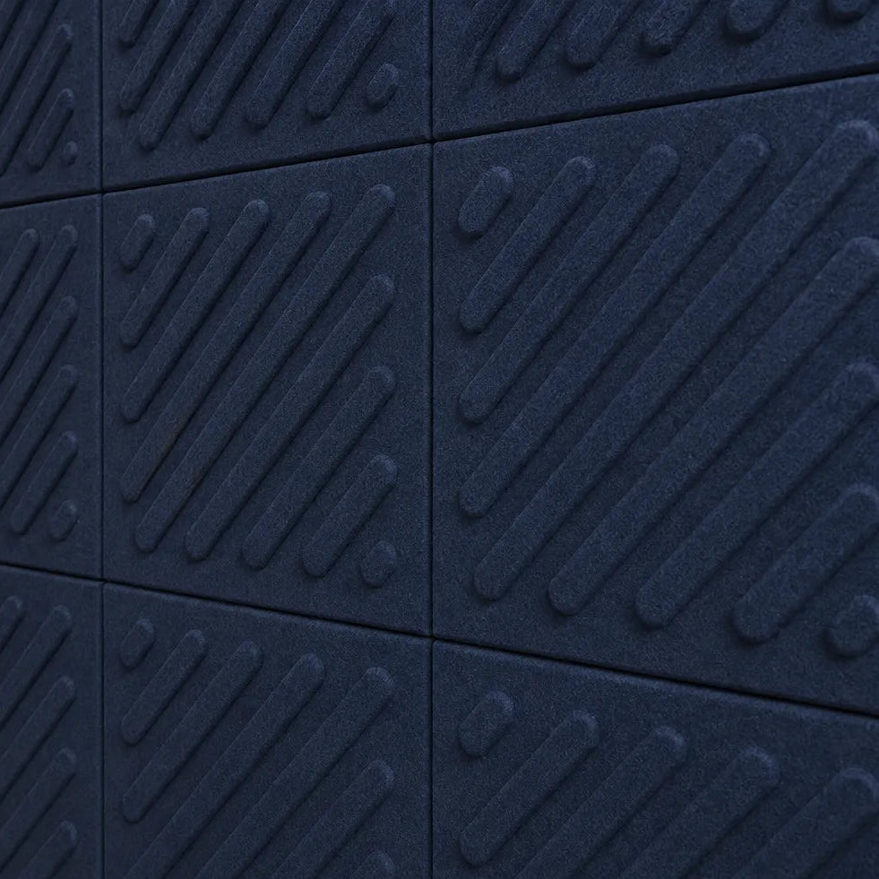 Close-up of navy acoustic felt wall panels highlighting the fibrous texture, raised relief and module connections