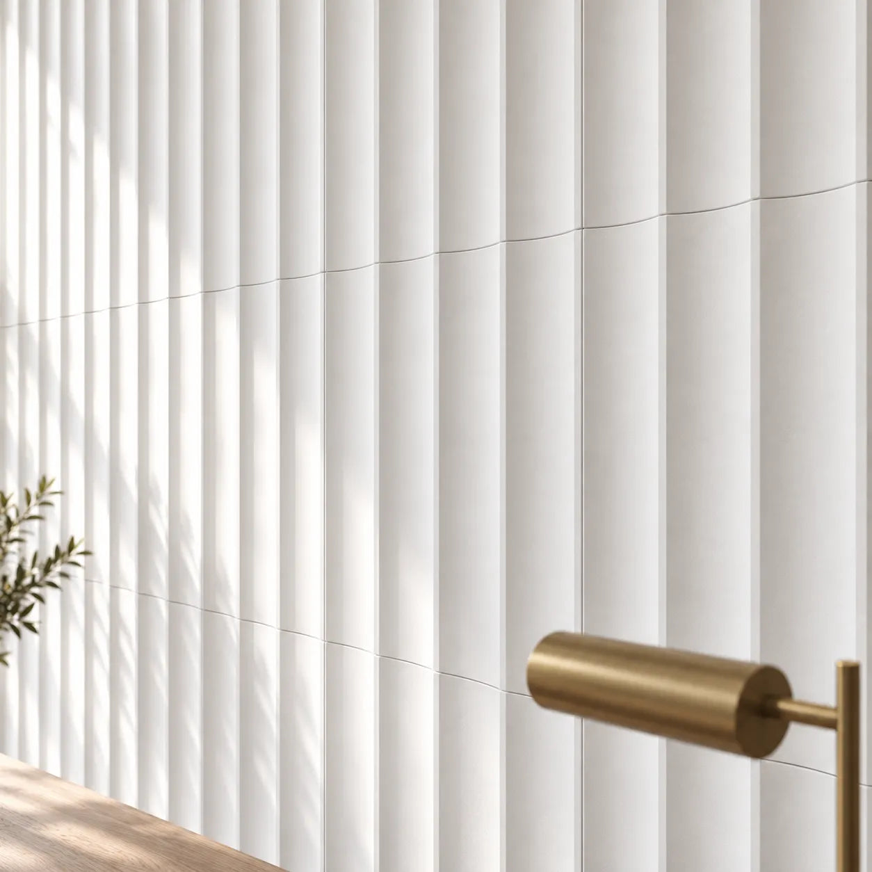 Close view of white Slats 3D gypsum wall panels showing vertical grooves and fine joints beside a brass desk lamp