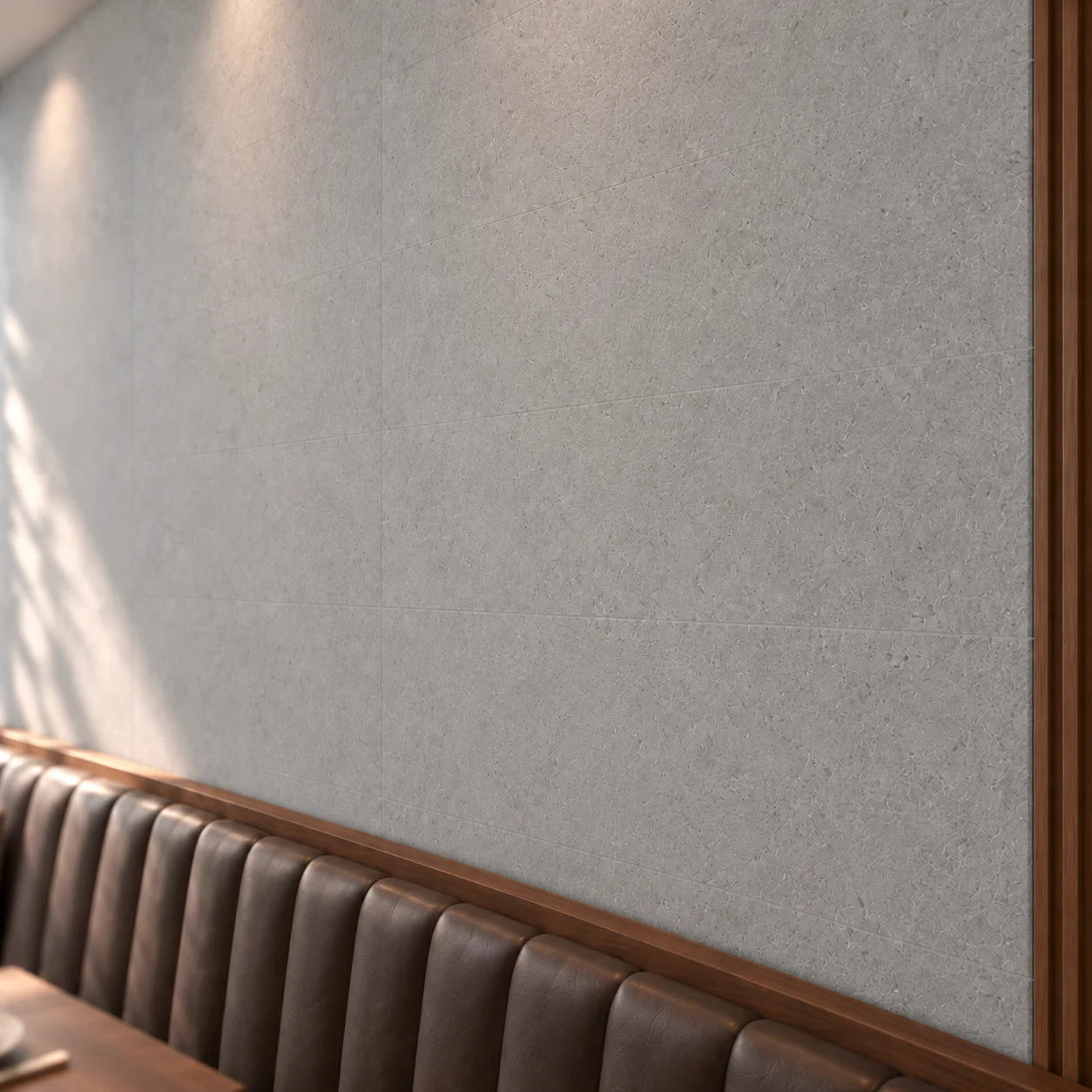 Close-up of Loft Concrete wall panels showing grey surface texture and subtle joints above leather seating.