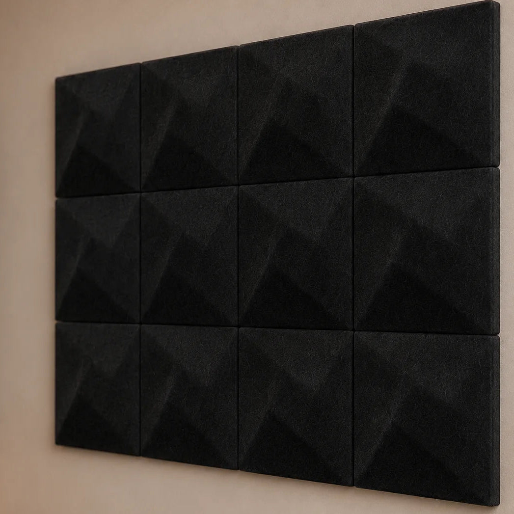 Close-up of black 3D felt acoustic panels showing the TWIST relief, panel joints and matte fibrous surface