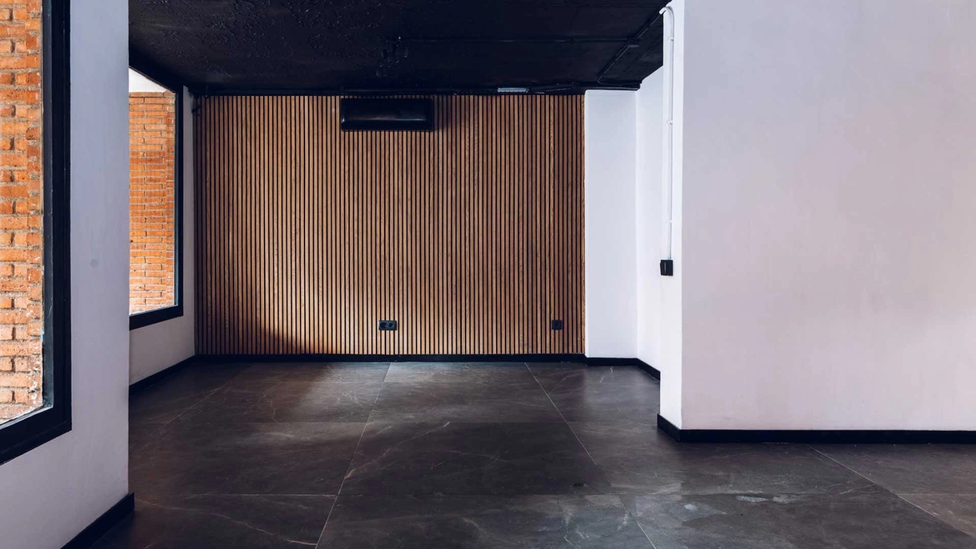 Black wall with Acoustic wood slat wall panelling long textured panels in modern interior Decormania UK