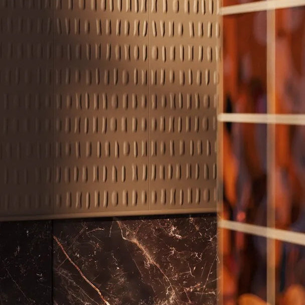 Close-up of taupe BOHEMIA ARSTYL wall panels above dark marble beside an amber glass partition