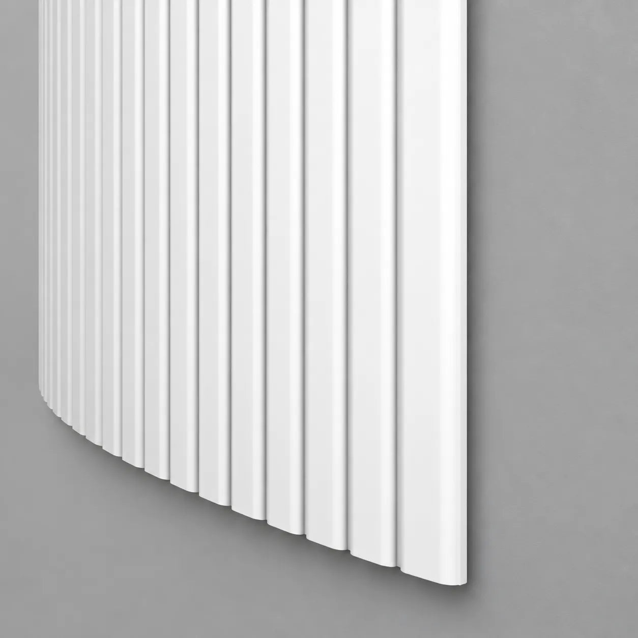 White CANELÉ L FLEX wall panel with rounded vertical ribs and a curved profile against a grey wall
