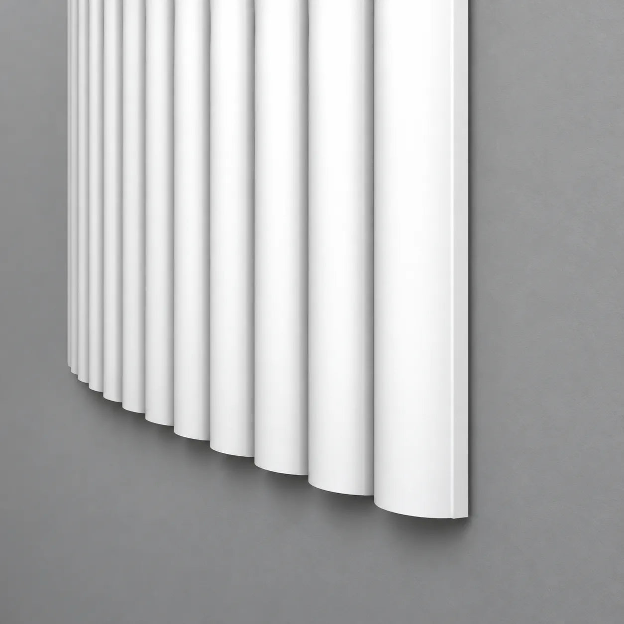 White CANELÉ XL FLEX wall panel with rounded vertical ribs and a curved profile against a grey wall