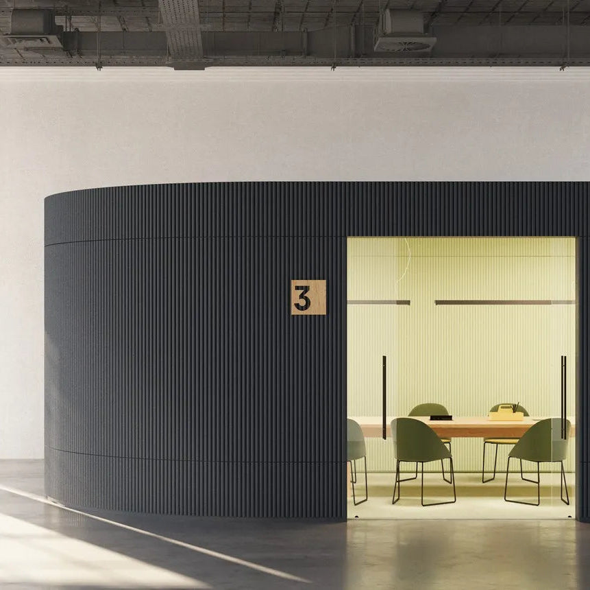 Dark grey CANELÉ XL FLEX panels wrapping a curved meeting room wall in an industrial office