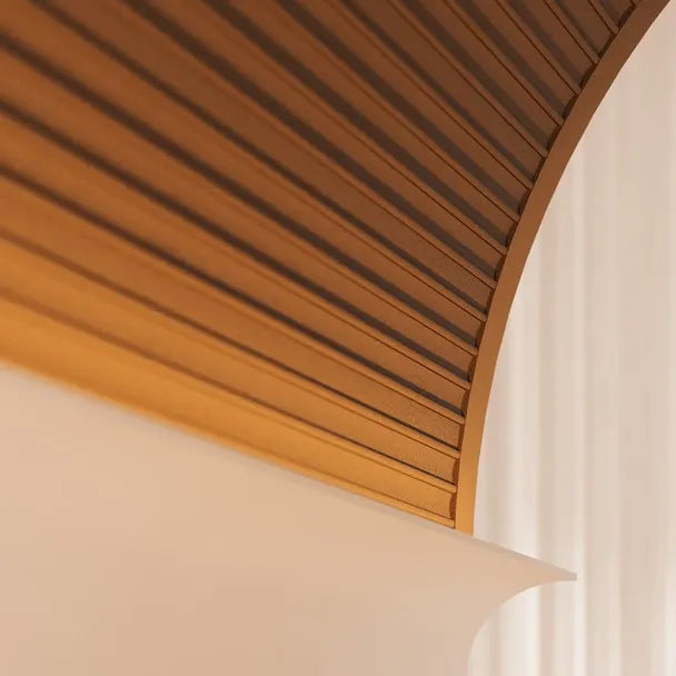 Close-up of DORIQUE FLEX ARSTYL flexible fluted panel fitted around a curved architectural feature