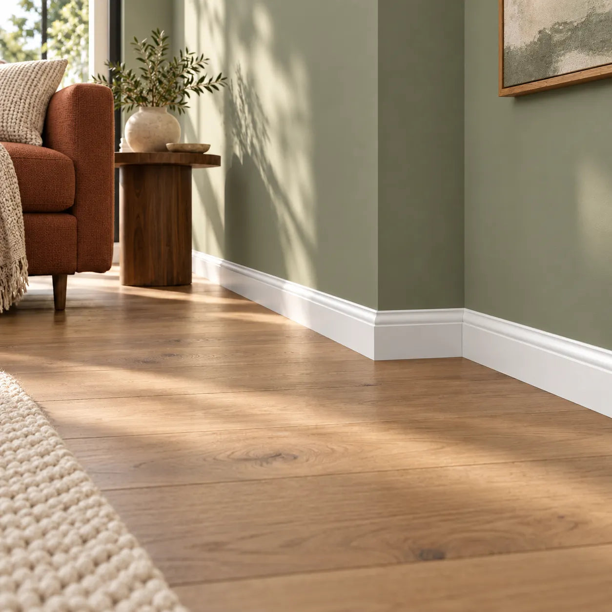 White skirting board fitted around an interior corner in a modern green living room
