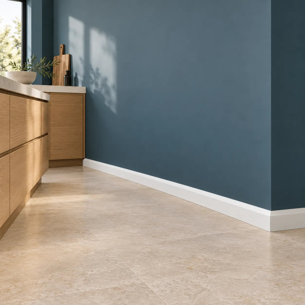 White FT1 WALLSTYL skirting board in a modern kitchen with blue walls