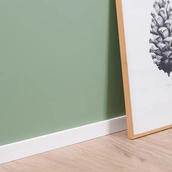White FT2 WALLSTYL skirting board in a modern green interior with framed wall art