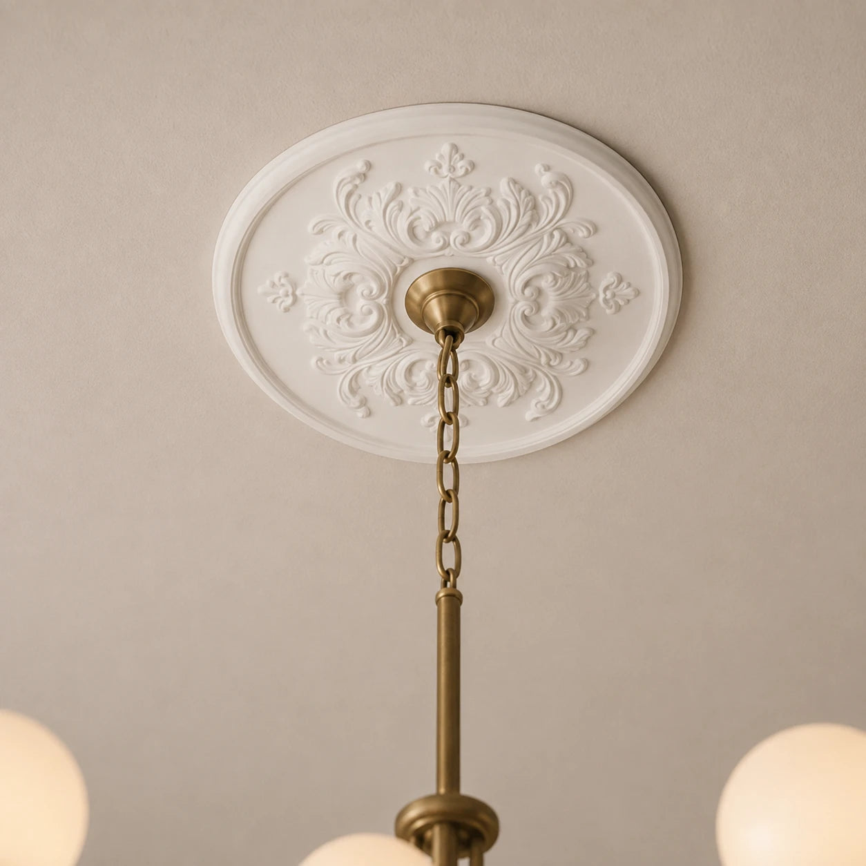 Close-up of the white Sara R1520 ceiling rose with symmetrical scrollwork and a centrally mounted brass chandelier.