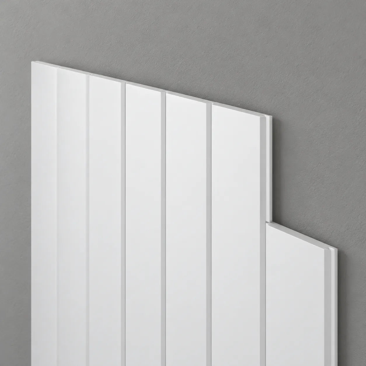 WG2 WALLSTYL white decorative wainscoting profiles arranged vertically on a grey wall