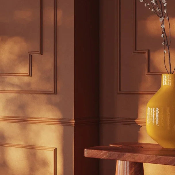 Close-up of terracotta-painted WL11 dado rail beside a marble console and yellow vase