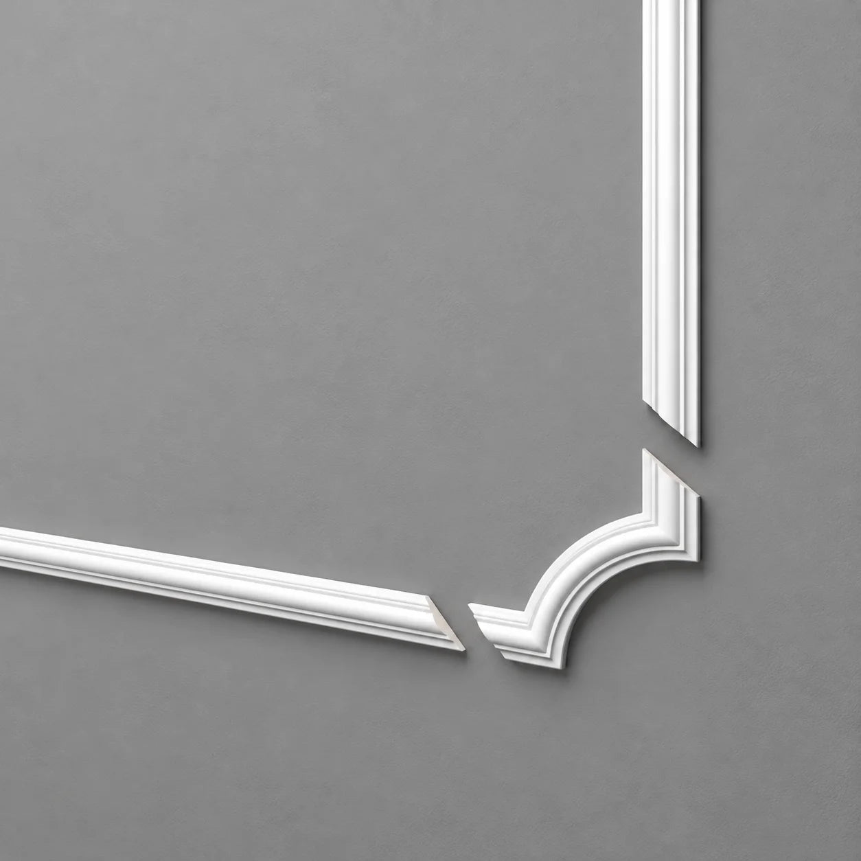 White Z102 ARSTYL corner moulding with matching straight profiles displayed separately on a grey wall
